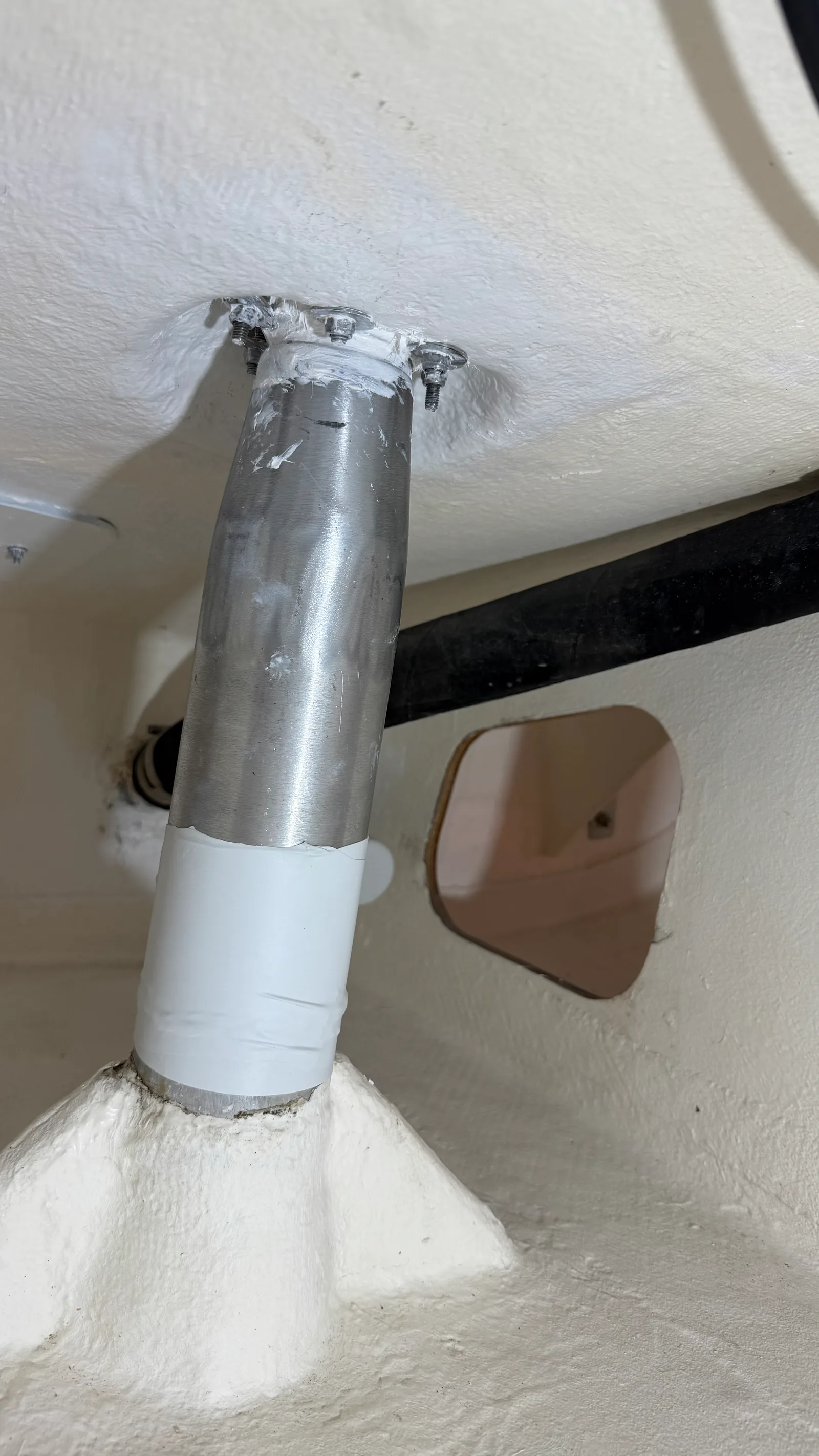 J/92s rudder stock refitted after replacing the bearings: clean aluminium shaft, deck seal remade in white epoxy, protective sleeve around the tube — the visible result