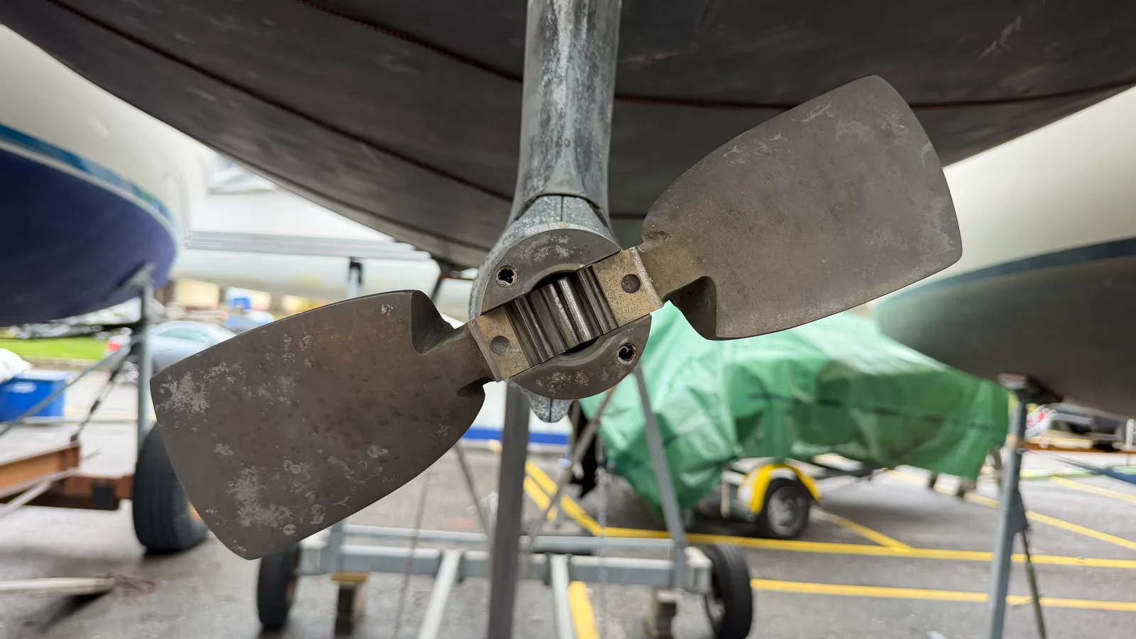 Gori propeller deployed under JAMAIS on the hard: each blade carries a toothed sector at the hub, the two gears mesh and lock the blade geometry — it is the shaft rotation that, via the blade geometry, opens or folds the propeller