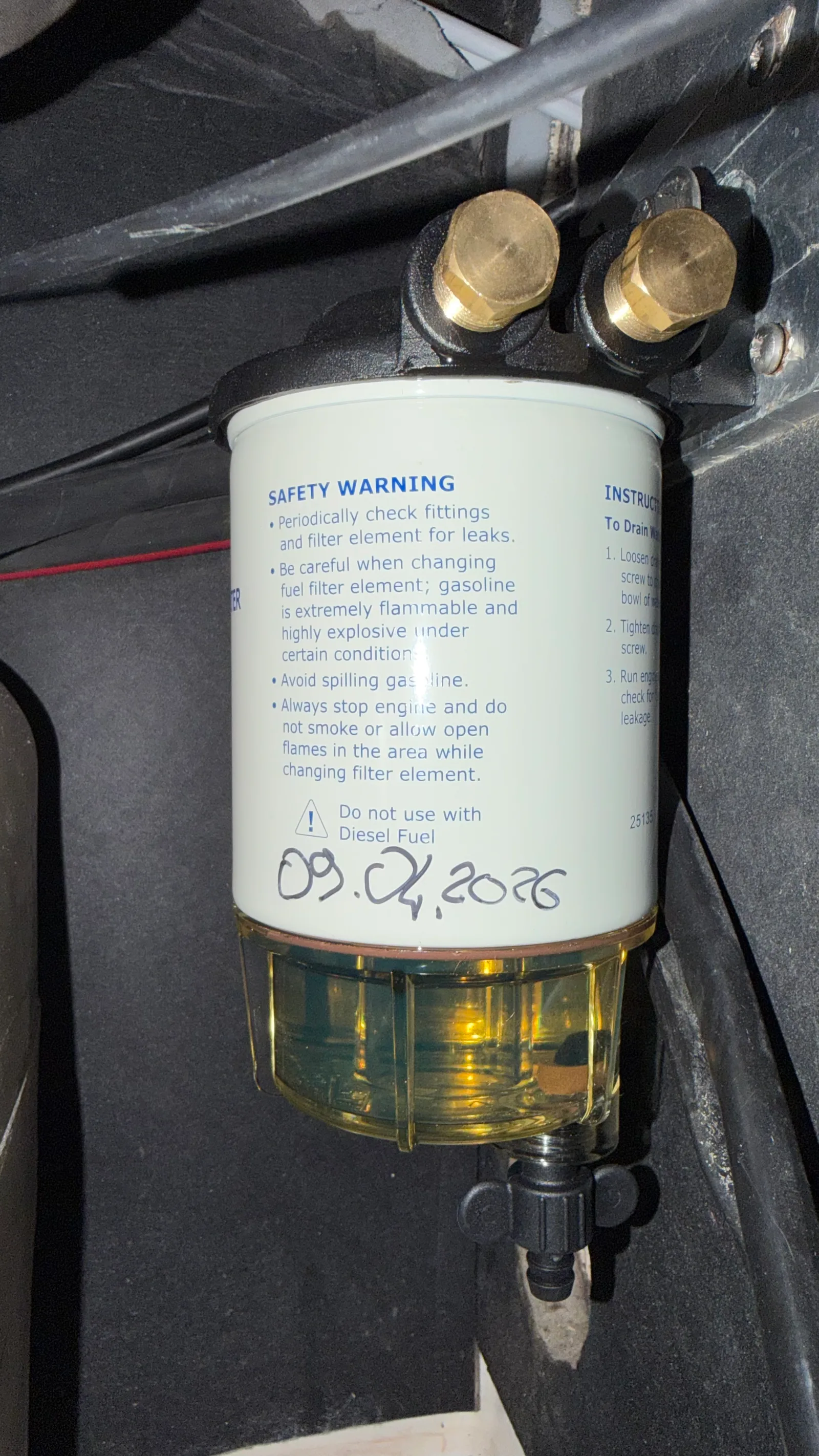 New diesel pre-filter with transparent bowl showing the amber fuel, black drain tap at the bottom, dated screw-on cartridge