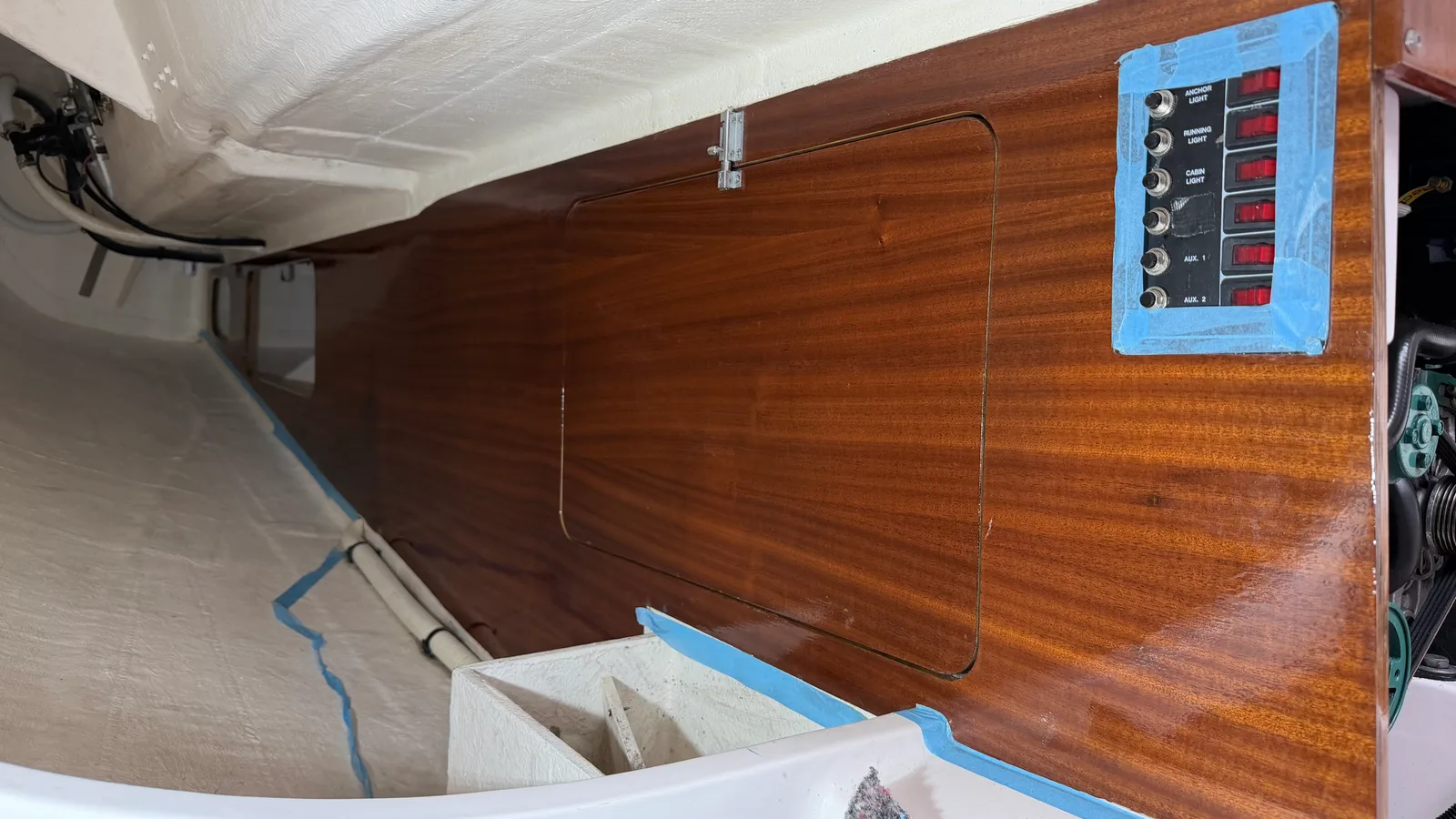 Mahogany bulkhead of the J/92s engine bay varnished with Veneziani Wood Line, sealed gloss finish, switch panel visible