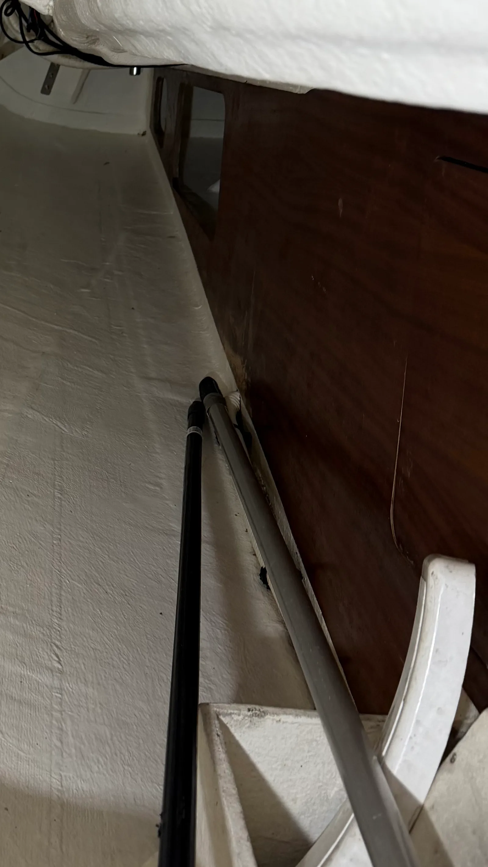 Before refit: starboard wooden bulkhead of the engine bay with the finish damaged by moisture — dark patch bottom-right where the varnish gave up and the plywood absorbed water