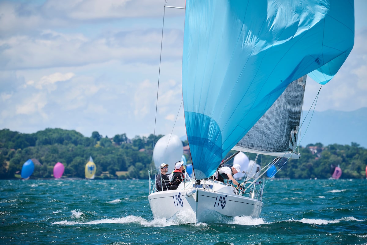 Voilier J/92s sous gennaker bleu pendant la régate du Bol d’Or sur le Lac Léman — vue dynamique de la coque blanche fendant l’eau.